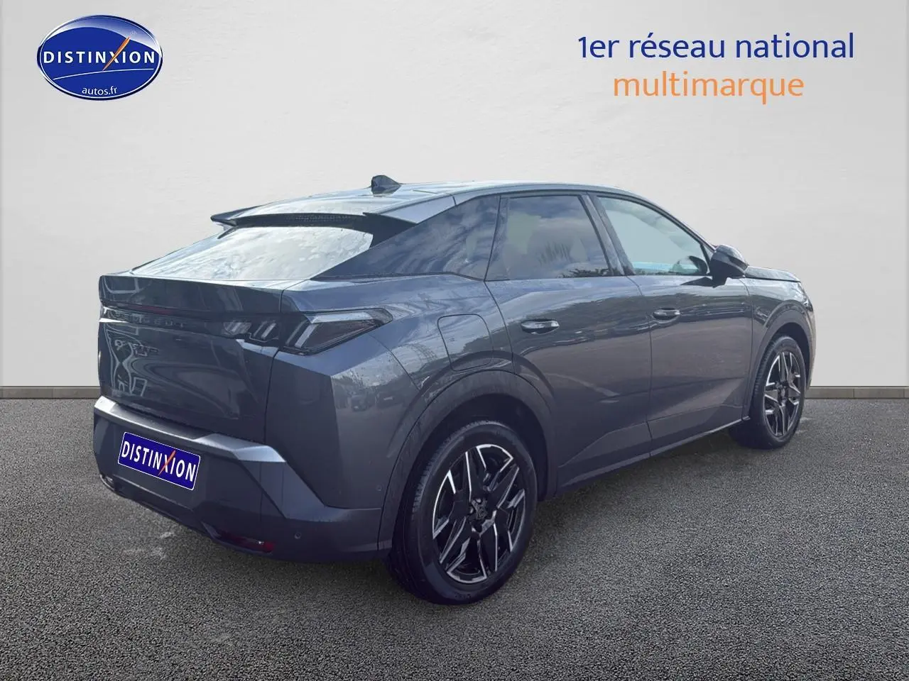 Vue 3/4 arrière droite d'un Peugeot 3008 gris titane 2025 avec jantes alu et becquet arrière distinctif.