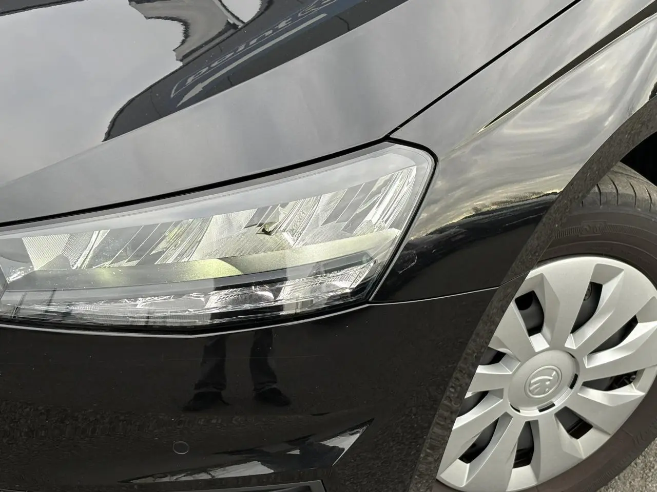 Intérieur avant droit de la SKODA FABIA 2024 noir Magic, sièges tissu gris et console avec boîte manuelle visible.