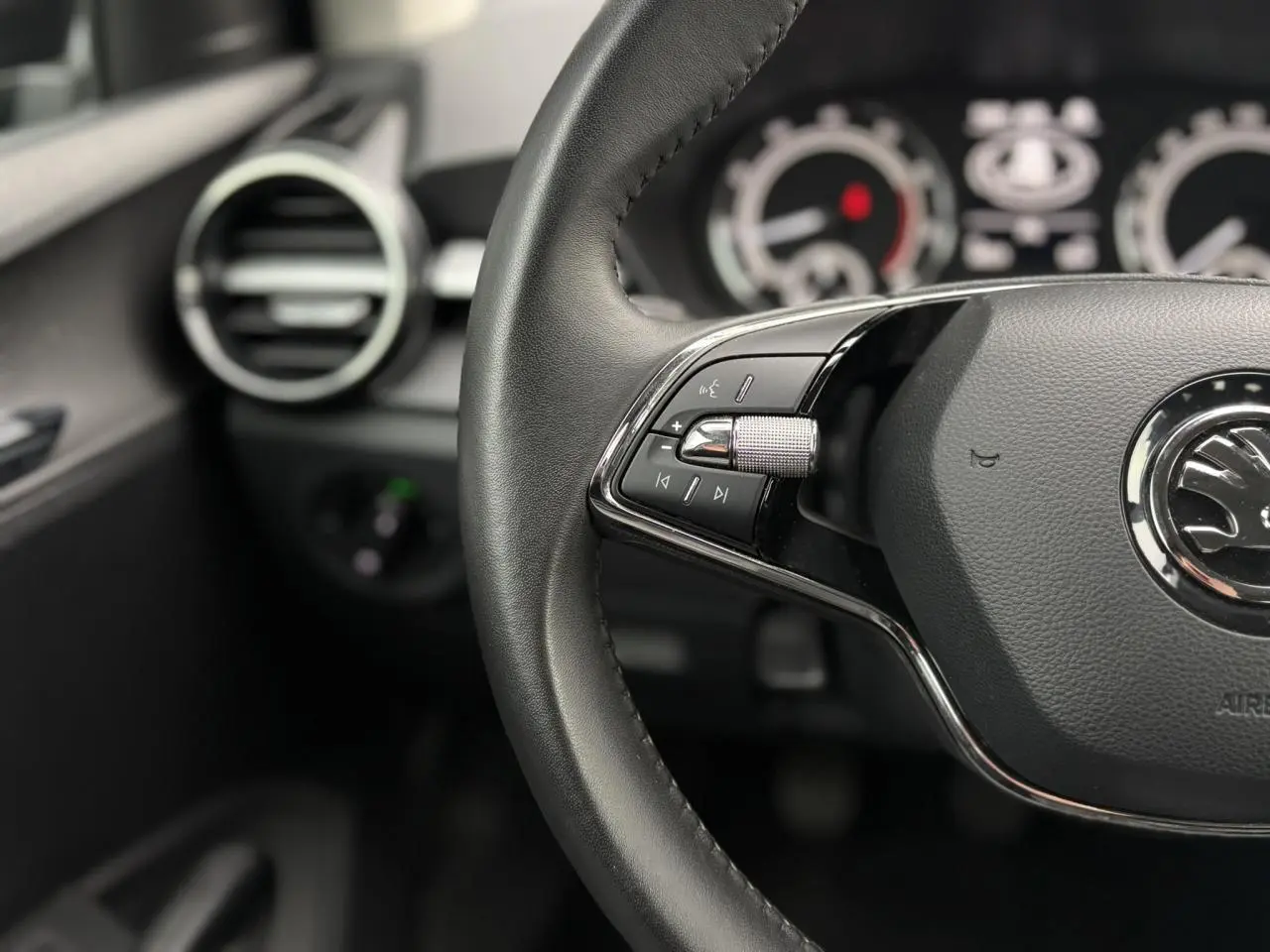 Vue 3/4 arrière droite d'une Skoda Fabia 2024 noir Magic avec feux arrière LED et jantes acier.