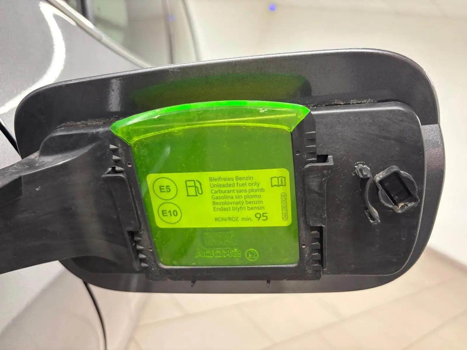 Bouchon de réservoir essence ouvert d'une Skoda Fabia 2023 gris graphite, avec indication carburant E5 et E10.