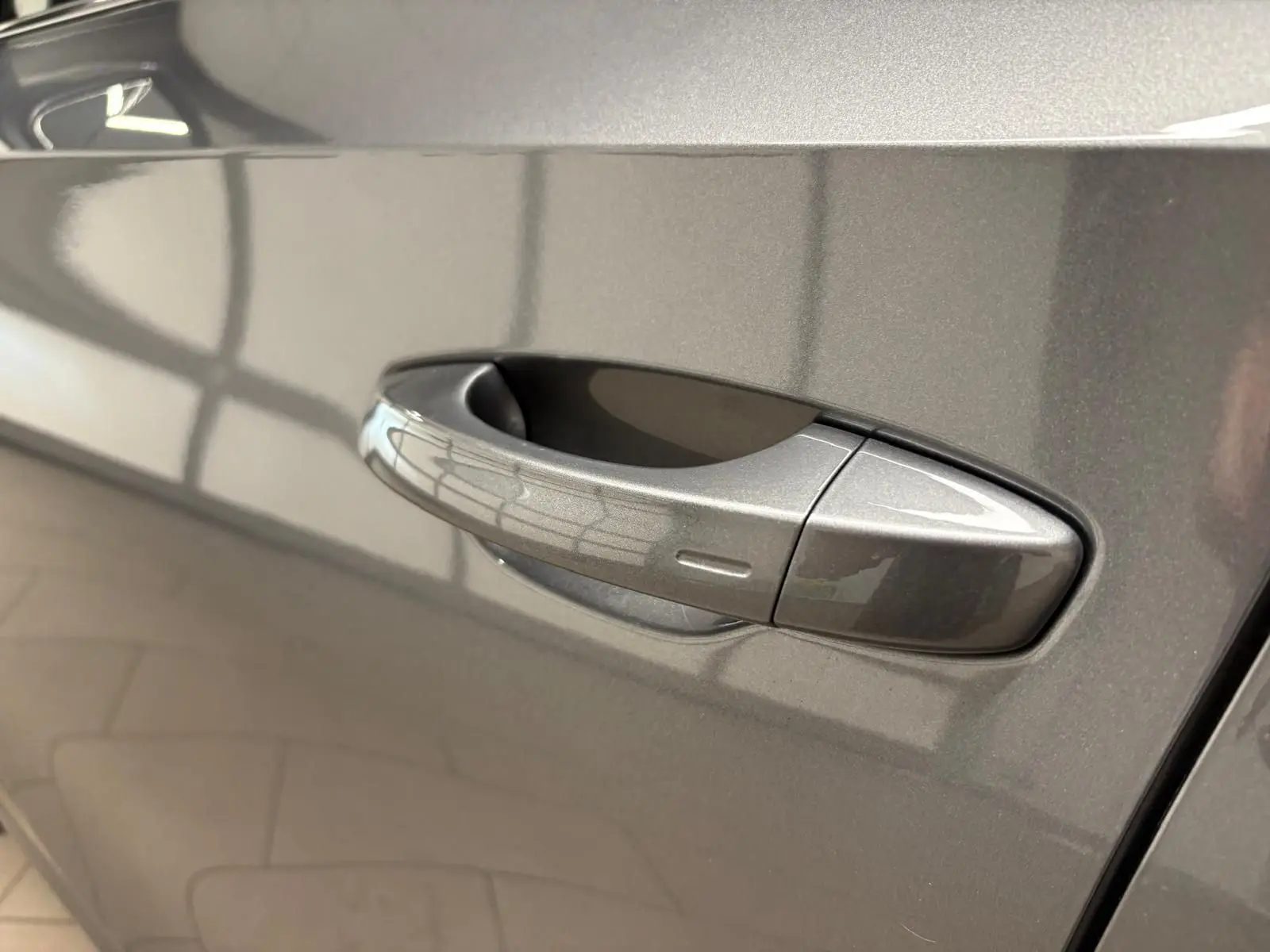 Poignée de porte côté gauche de la Skoda Fabia 2023 en gris graphite métallisé, vue rapprochée sur la carrosserie lisse.