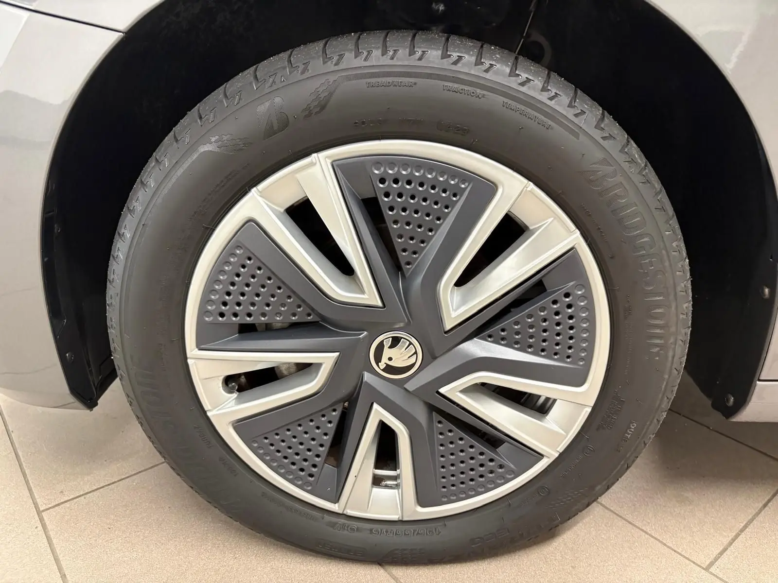 Gros plan sur la roue avant droite d’une Skoda Fabia 2023 gris graphite avec jante alliage au design moderne.