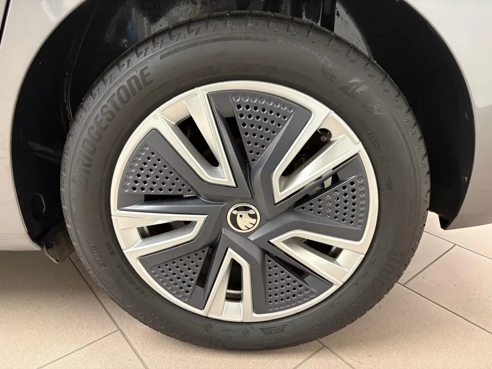 Gros plan sur la roue avant droite d'une Skoda Fabia 2023 gris graphite avec jante alliage au design moderne.