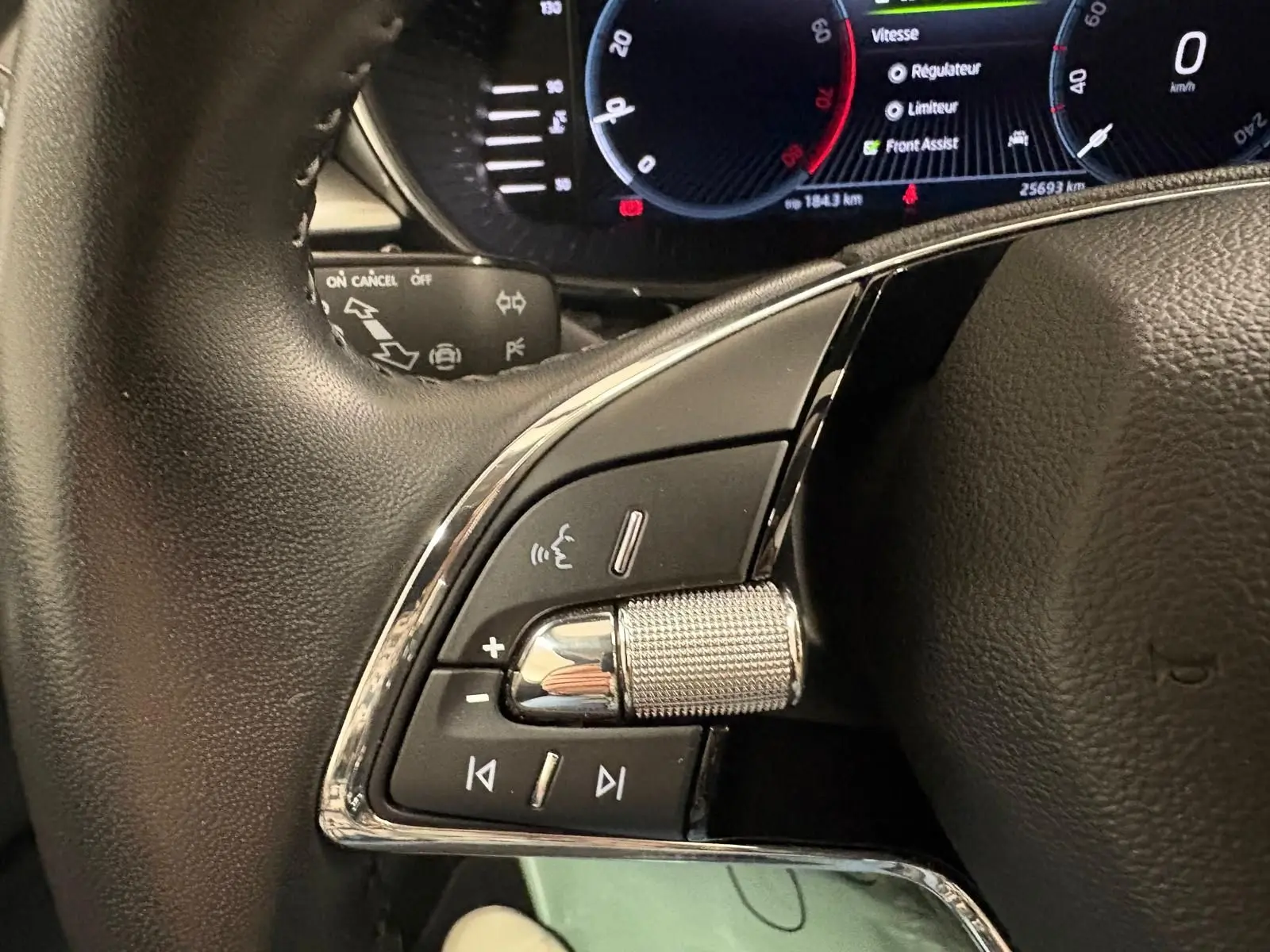 Gros plan sur les commandes au volant côté gauche de la Skoda Fabia 2023 gris graphite avec tableau de bord numérique.