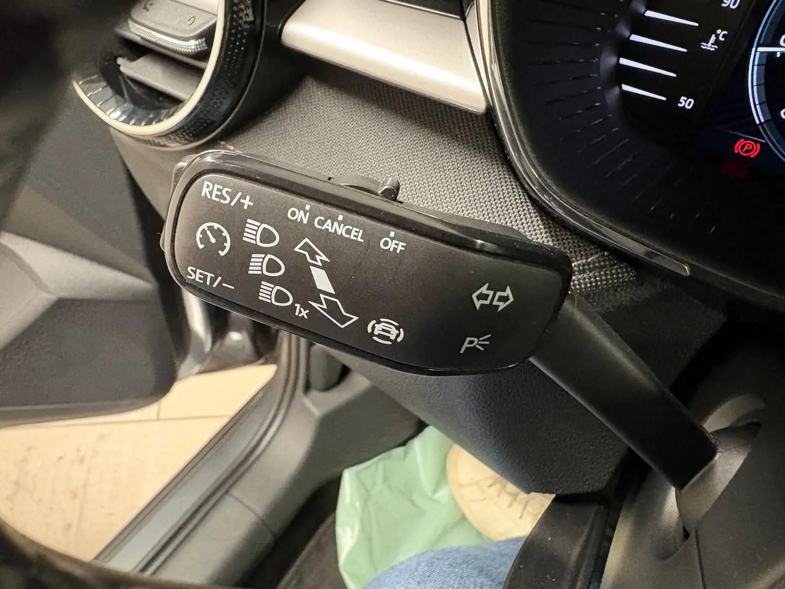 Gros plan sur la commande de régulateur de vitesse à gauche du volant dans l’habitacle d’une Skoda Fabia gris graphite 2023.