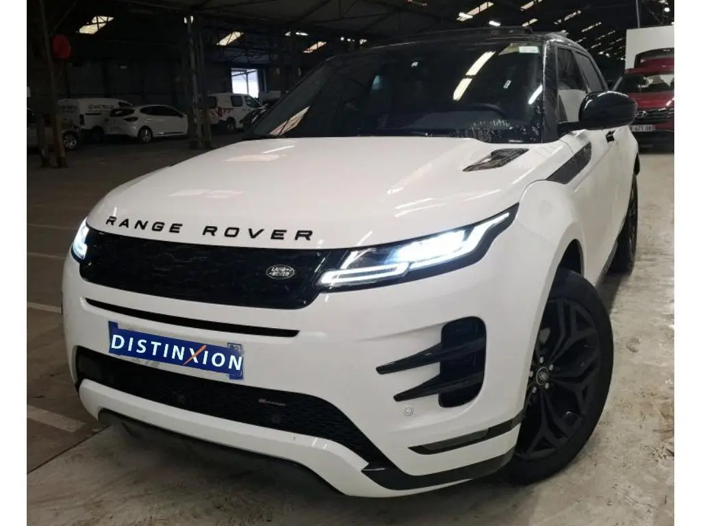 Vue 3/4 avant droite du Range Rover Evoque blanc avec toit noir et jantes noires dans un garage.