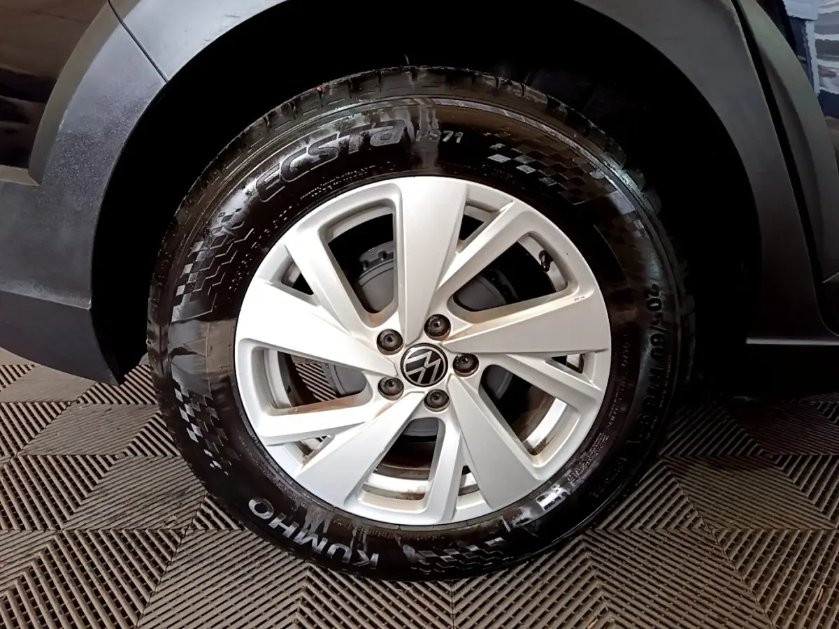 Gros plan sur la roue avant gauche du Volkswagen Taigo noir, mettant en valeur la jante argentée et le pneu Kumho.