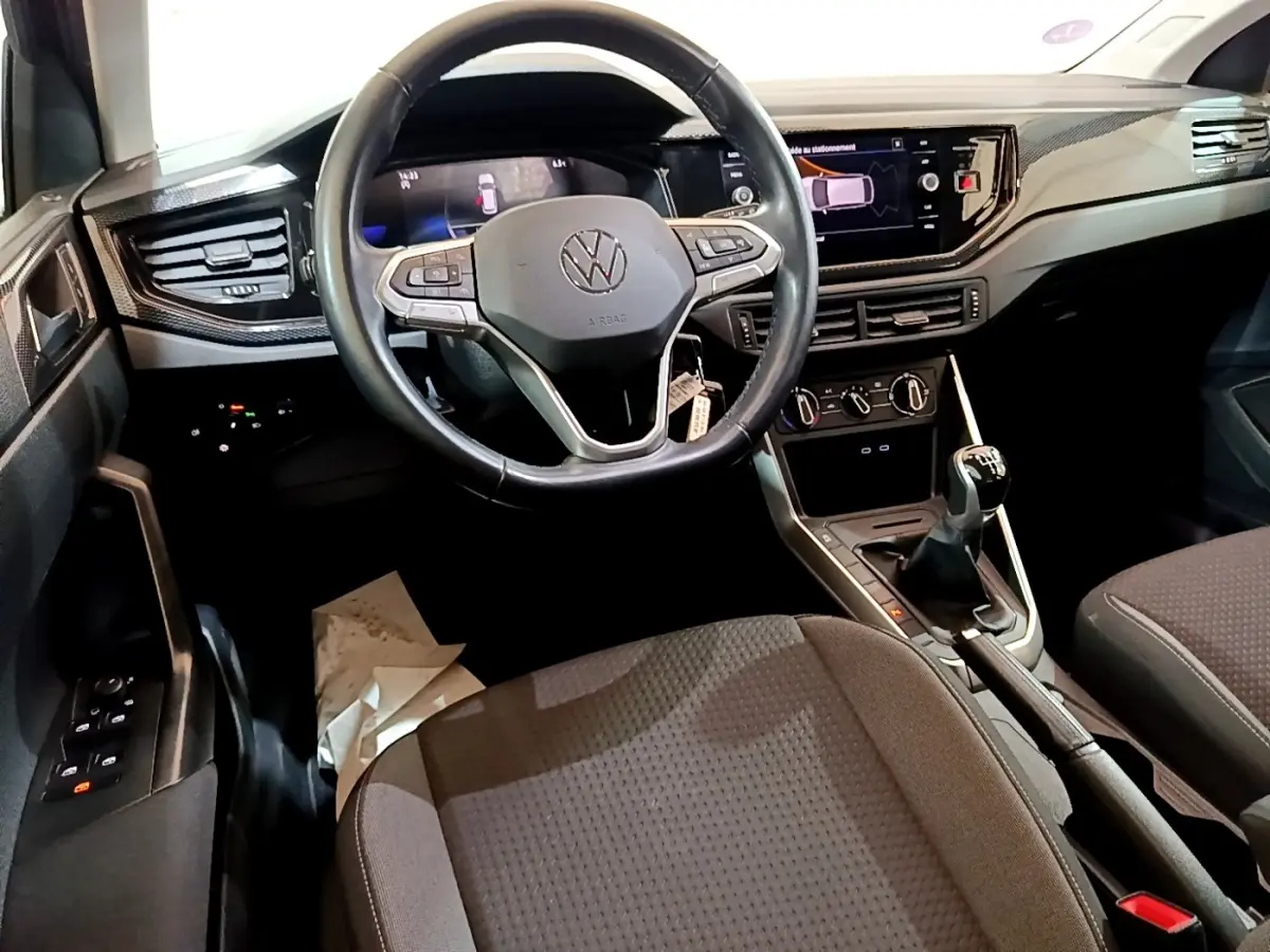 Vue intérieure du tableau de bord et volant cuir noir du Volkswagen Taigo 1.0 TSI 95 Life 2023 avec boîte manuelle.