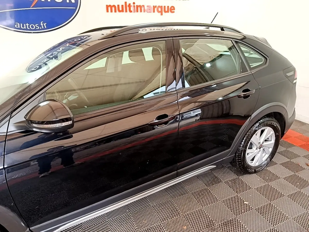 Vue latérale droite du Volkswagen Taigo noir 2023 avec rétroviseurs électriques et jantes alliage visibles.