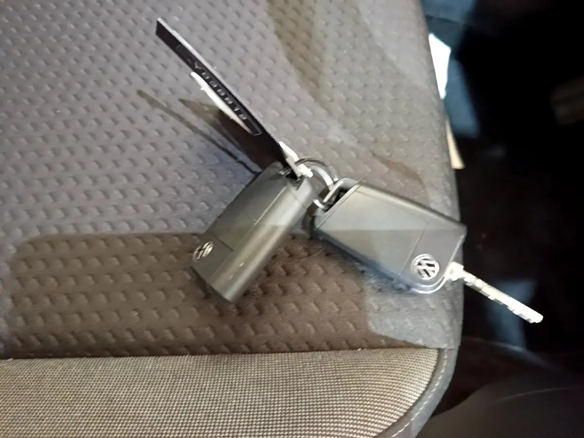 Clé noire Volkswagen Taigo posée sur un siège tissu gris foncé à motifs géométriques.