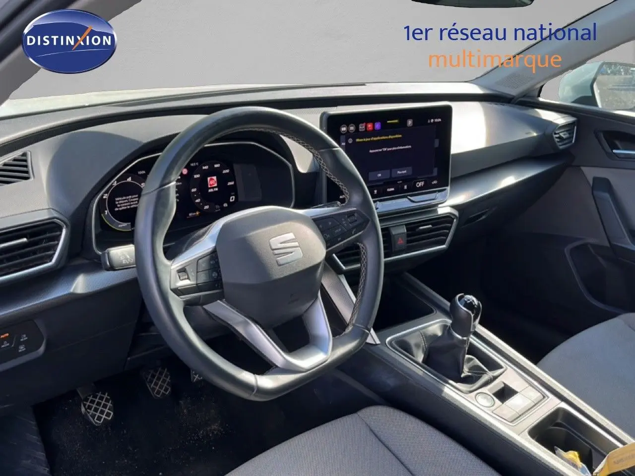 Vue intérieure côté conducteur du tableau de bord et volant du SEAT LEON blanc neige 2025 avec boîte manuelle.