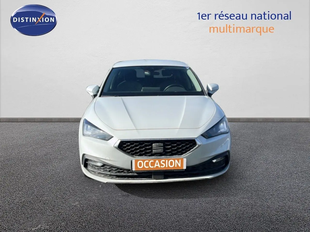 Vue frontale d'une SEAT Leon blanc neige 2025 avec calandre hexagonale et phares LED distinctifs.