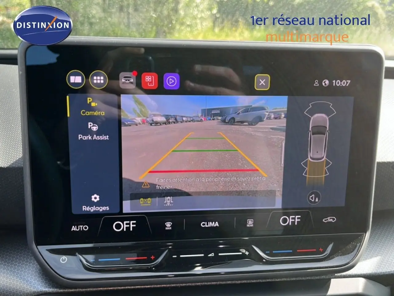 Écran tactile intérieur montrant la caméra de recul active d'une SEAT LEON blanc neige, version 2025, avec assistance au stationnement.