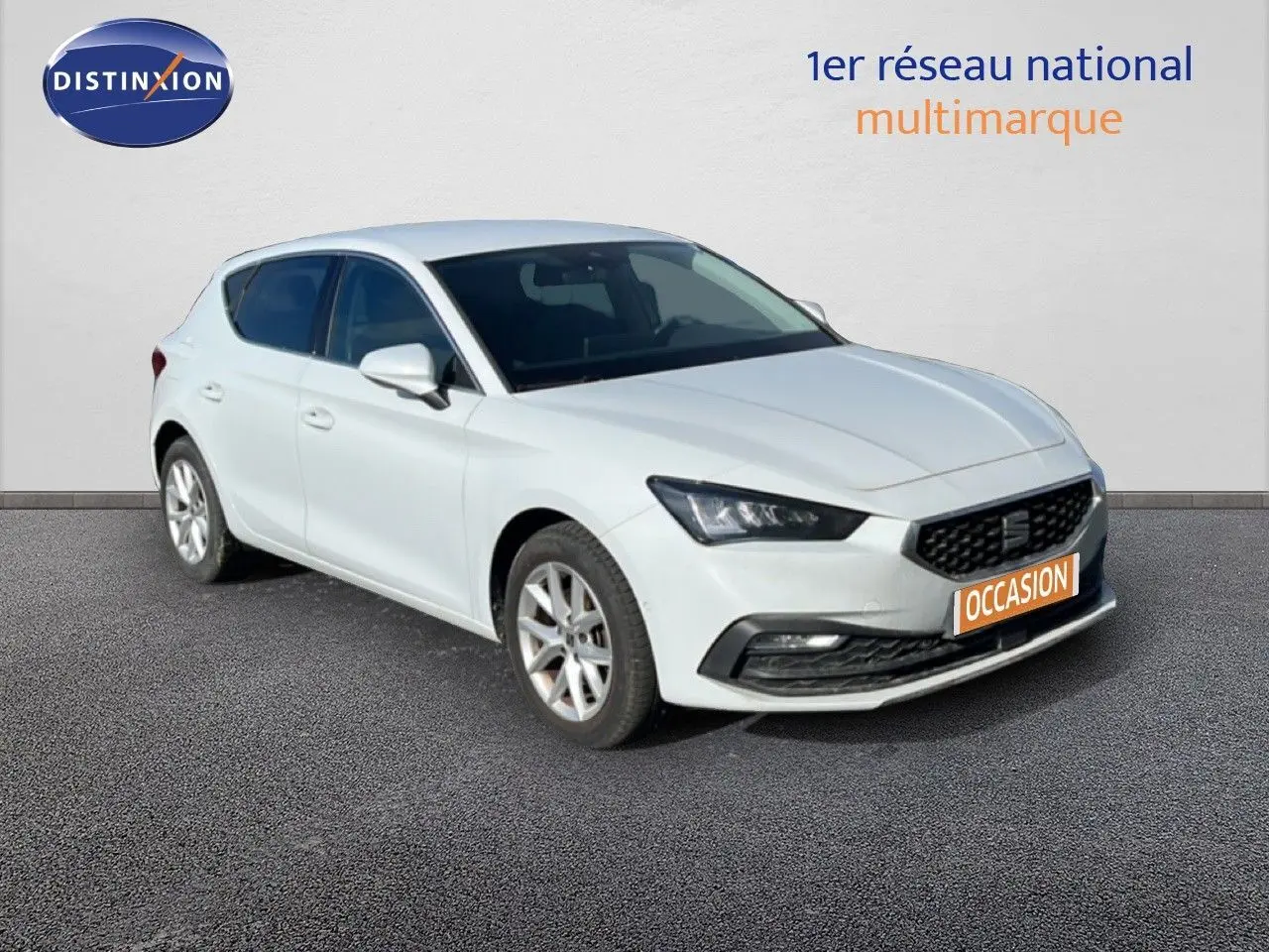 SEAT LEON blanc neige en 3/4 avant droit, mettant en valeur sa calandre noire et ses phares LED distinctifs.