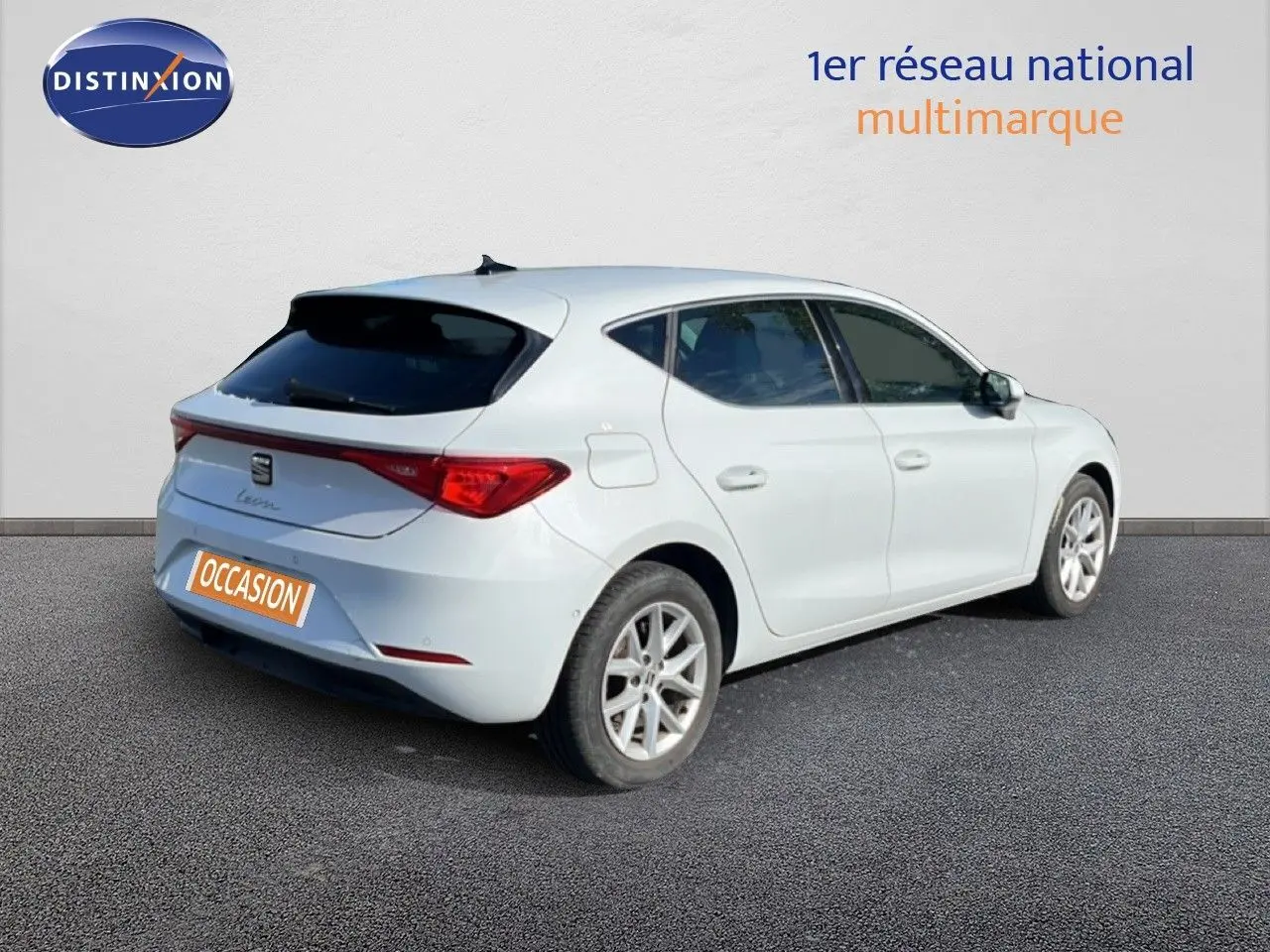 SEAT Leon blanc neige vue 3/4 arrière droit, hayon fermé et vitres teintées sur fond neutre.