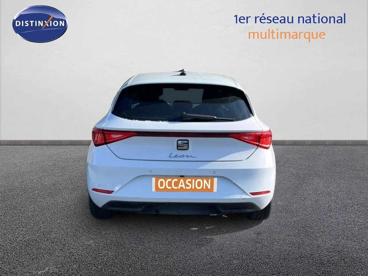 Vue arrière d'une SEAT Leon blanche neige 2025 avec feux LED et logo distinctif sur fond neutre.