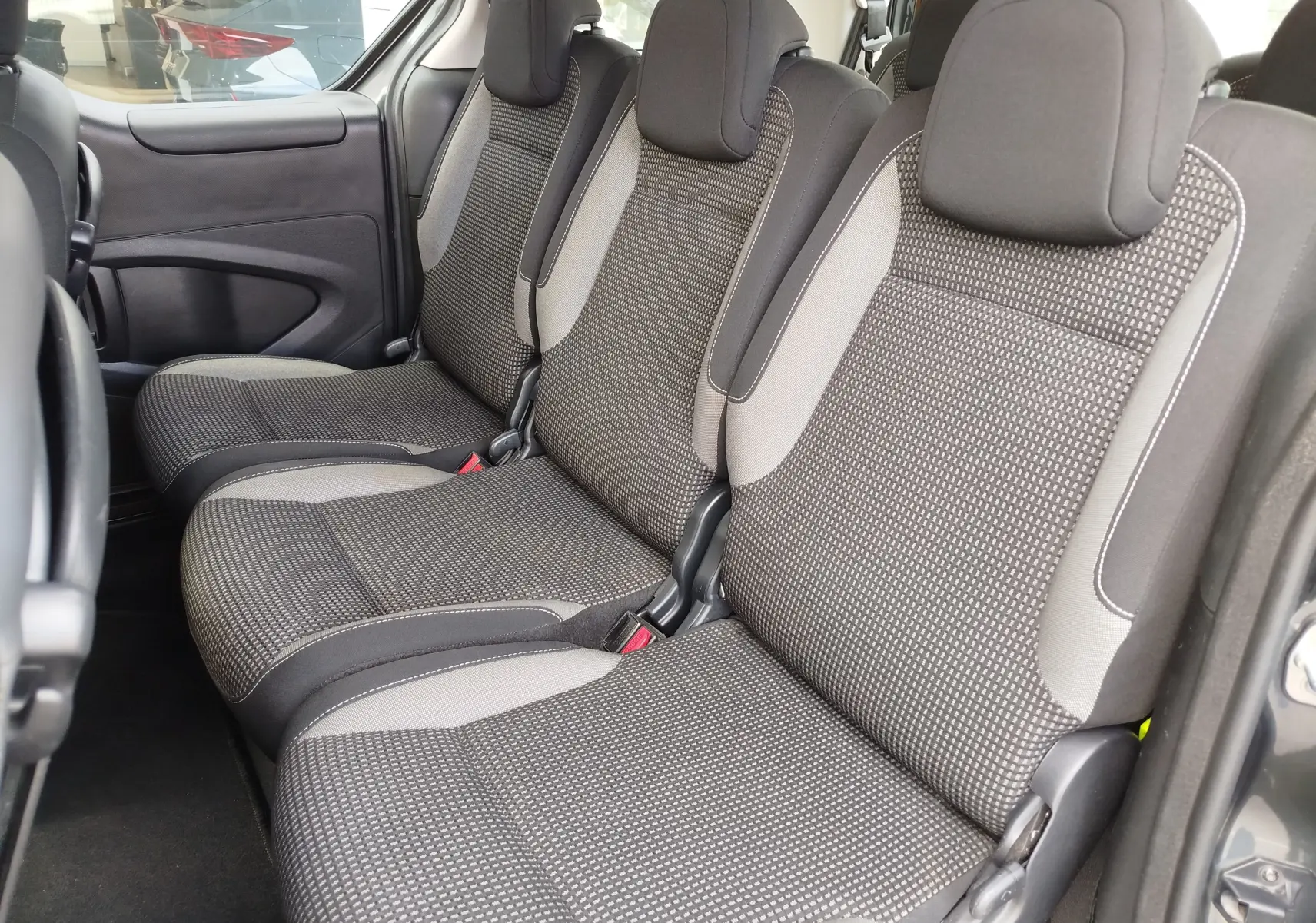 Vue intérieure côté droit montrant les trois sièges tissu gris du Peugeot Partner Tepee 2017, version Outdoor.