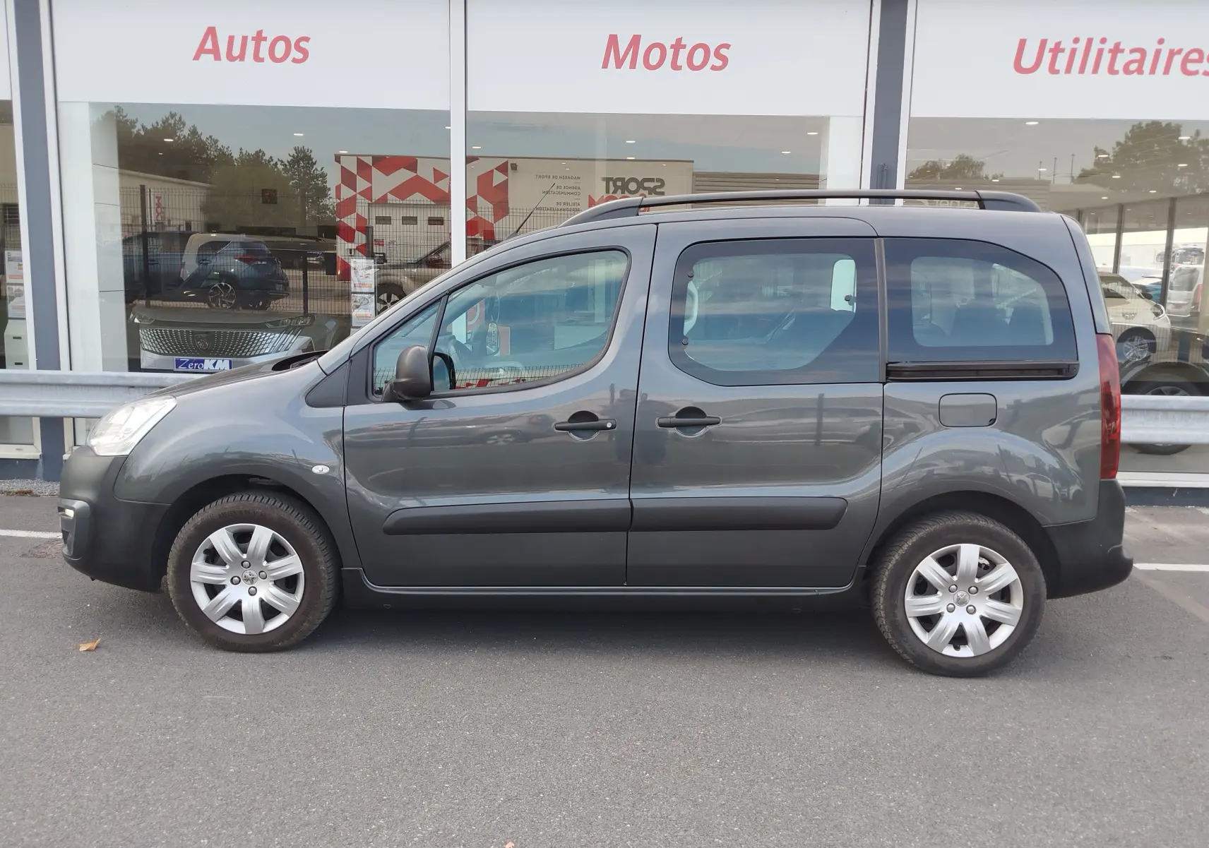 Profil droit d’un Peugeot Partner Tepee gris foncé de 2017, avec portes coulissantes et jantes alliage visibles.