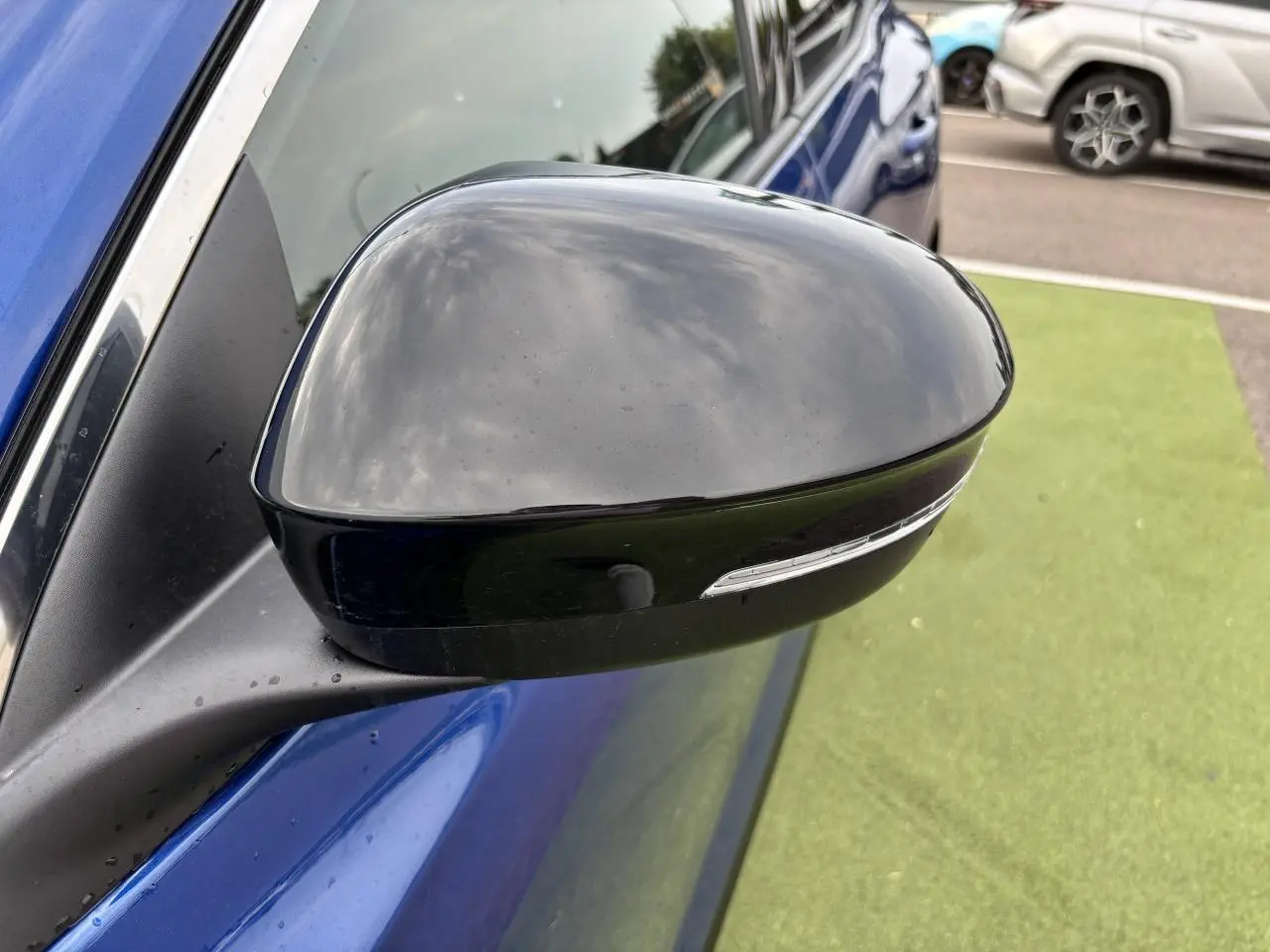 Rétroviseur noir étoilé côté gauche du Renault Austral bleu Iron Metal, avec clignotant intégré visible.