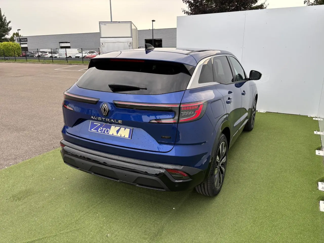 Vue 3/4 arrière droite d'un Renault Austral bleu Iron Metal avec feux arrière LED et hayon motorisé.