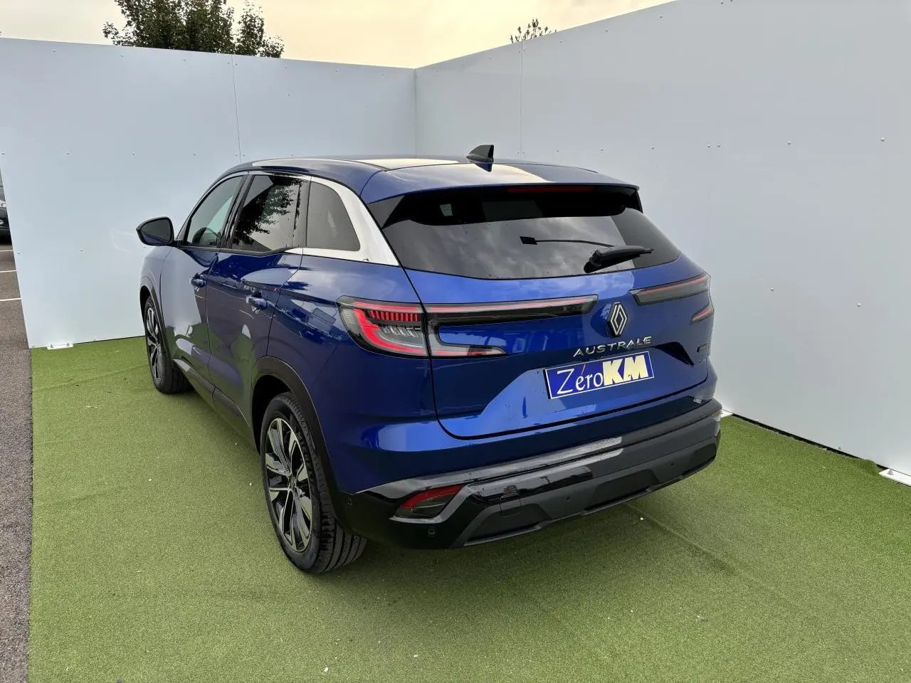 Vue 3/4 arrière droite d'un Renault Austral bleu Iron Metal avec feux arrière LED et jantes alliage noires.