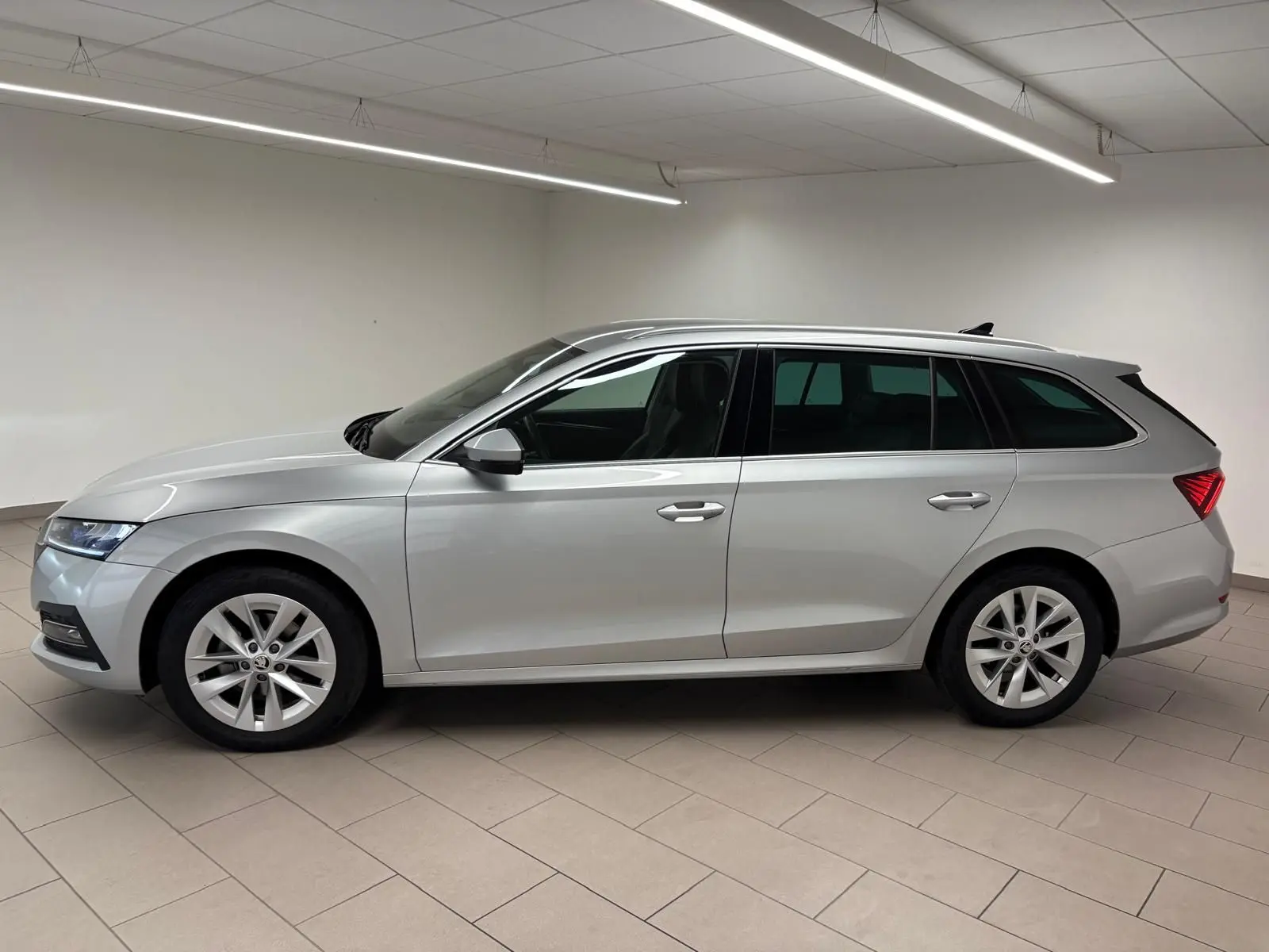Vue latérale droite d'une Skoda Octavia Combi gris argent 2023 avec jantes alliage et feux arrière LED distinctifs.