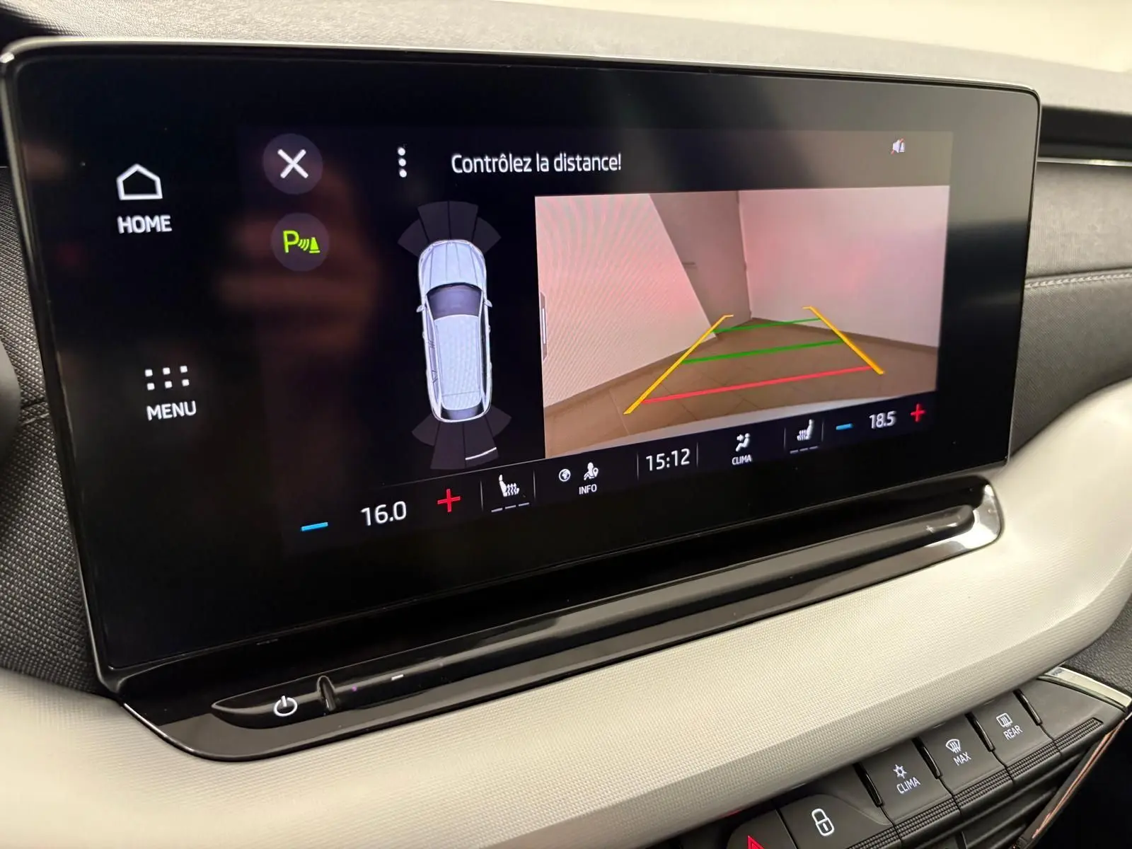 Écran tactile central de la Skoda Octavia Combi gris argent 2023 montrant la caméra de recul et les commandes climatiques.