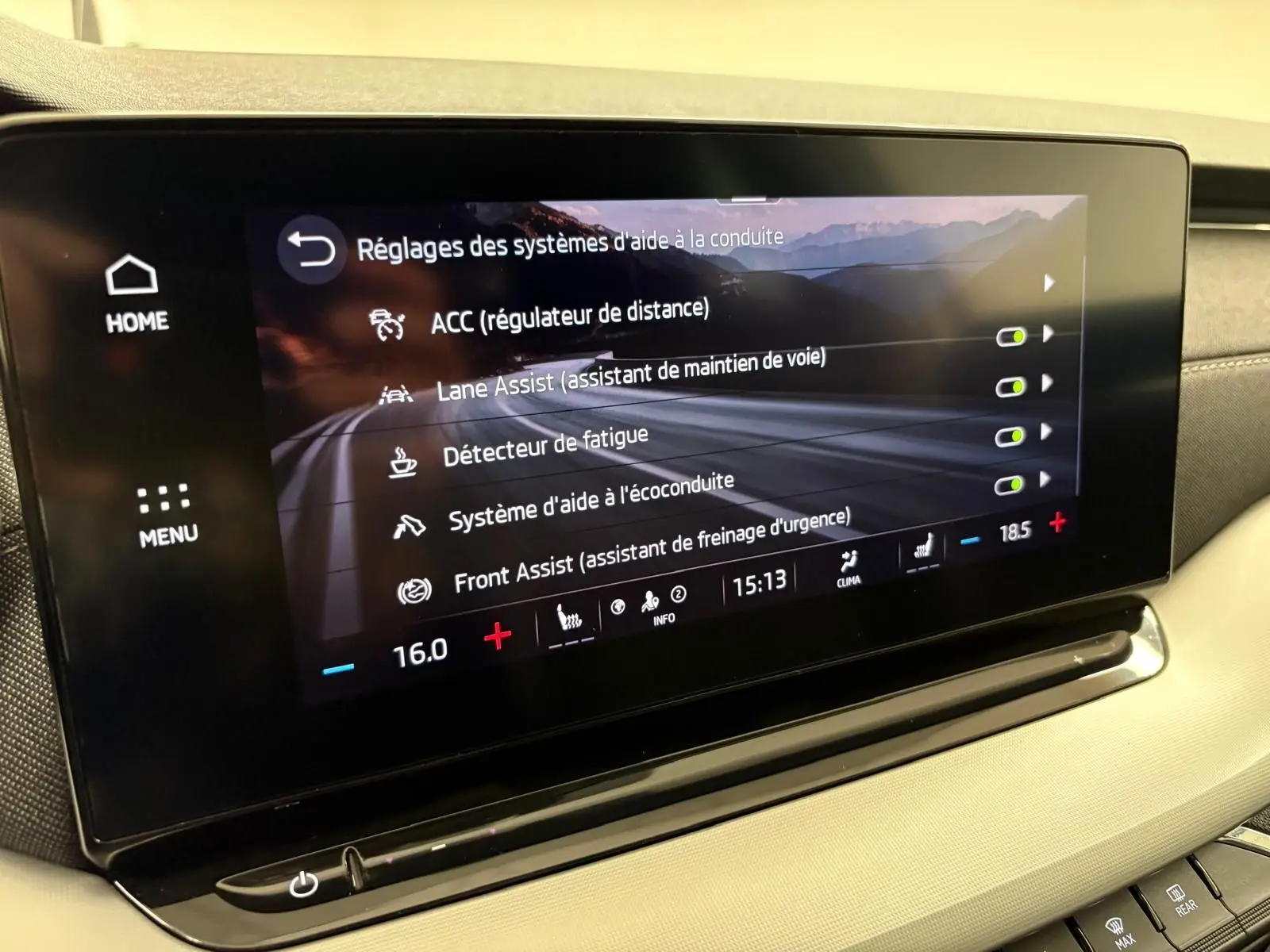Écran tactile intérieur du Skoda Octavia Combi gris argent 2023 affichant les réglages d'aide à la conduite.
