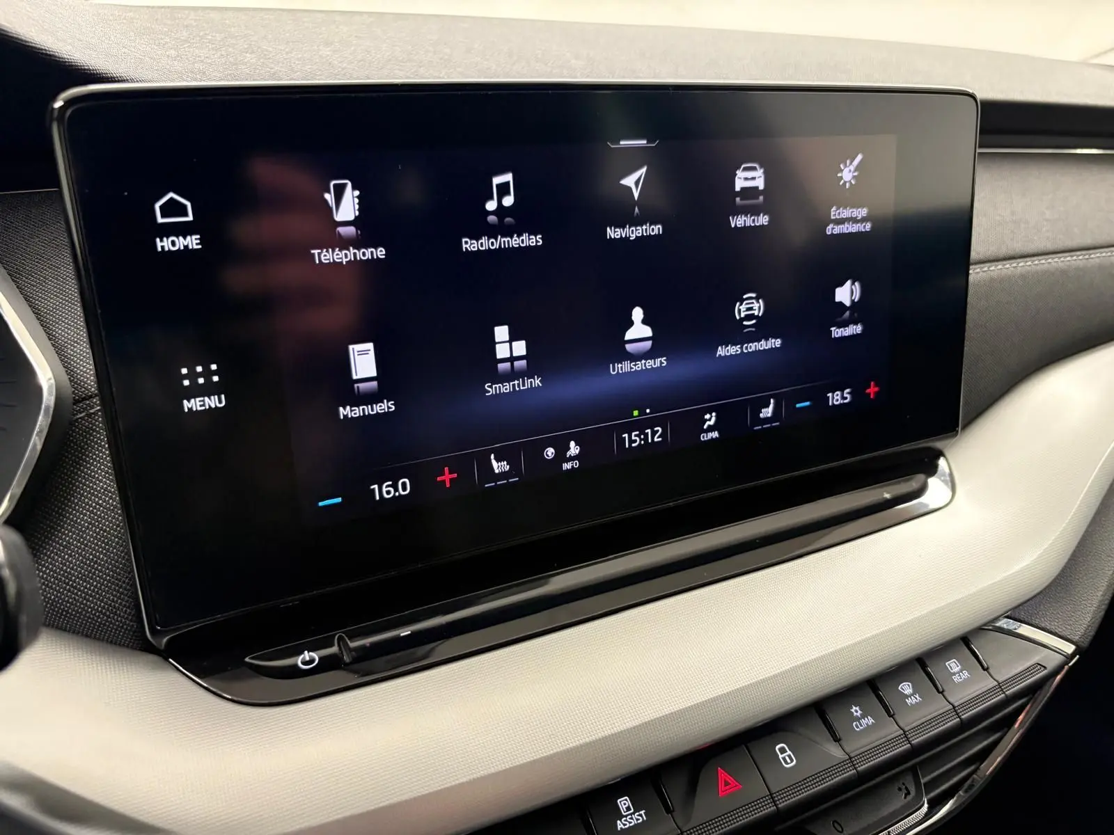 Écran tactile central du tableau de bord de la Skoda Octavia Combi gris argent 2023, affichant menu multimédia et climatisation.