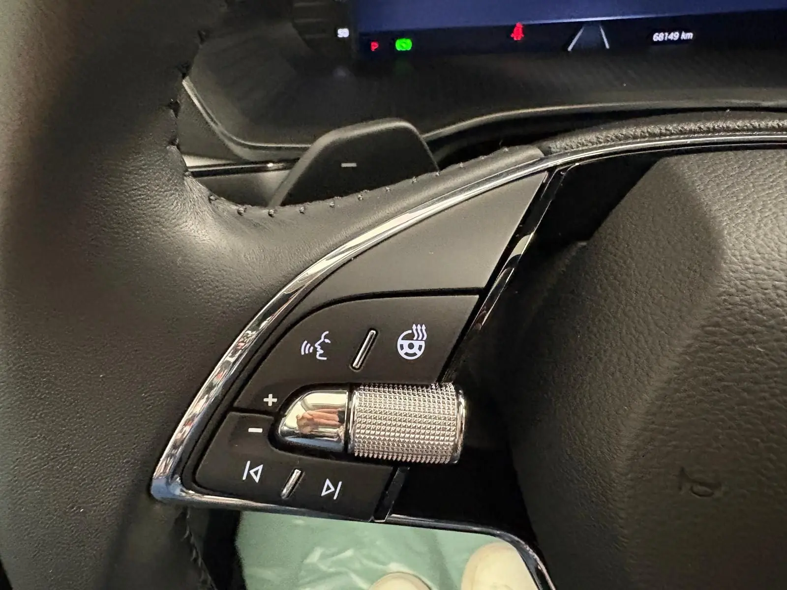 Gros plan sur les commandes gauche du volant en cuir noir de la Skoda Octavia Combi gris argent 2023.