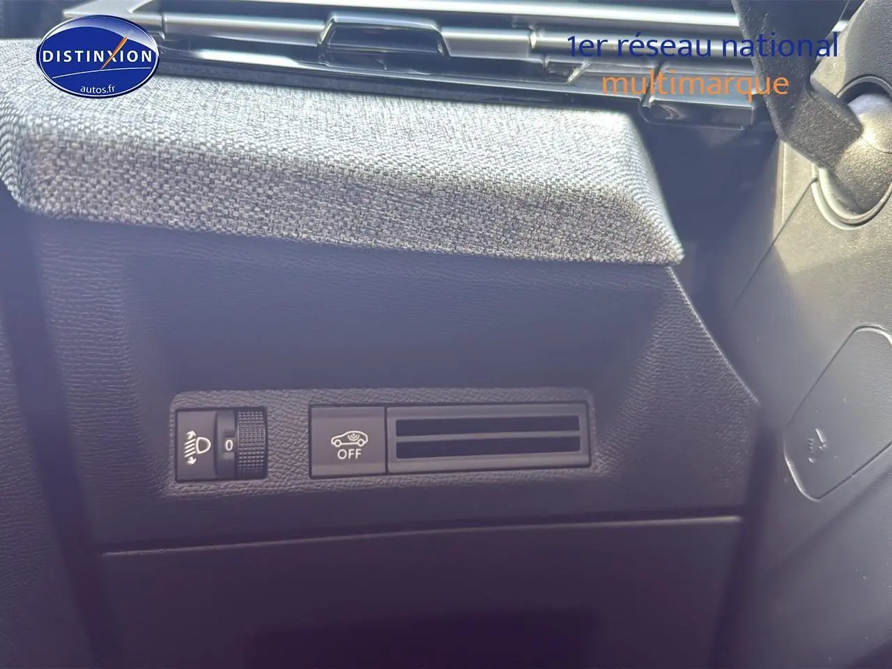 Détail du tableau de bord noir avec commandes d'éclairage et assistance du Peugeot 3008 gris titane 2025.