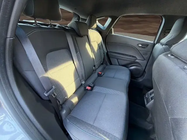 Vue intérieure côté droit montrant la banquette arrière tissu noir du Renault Captur 2024 gris Cassiopée toit noir.