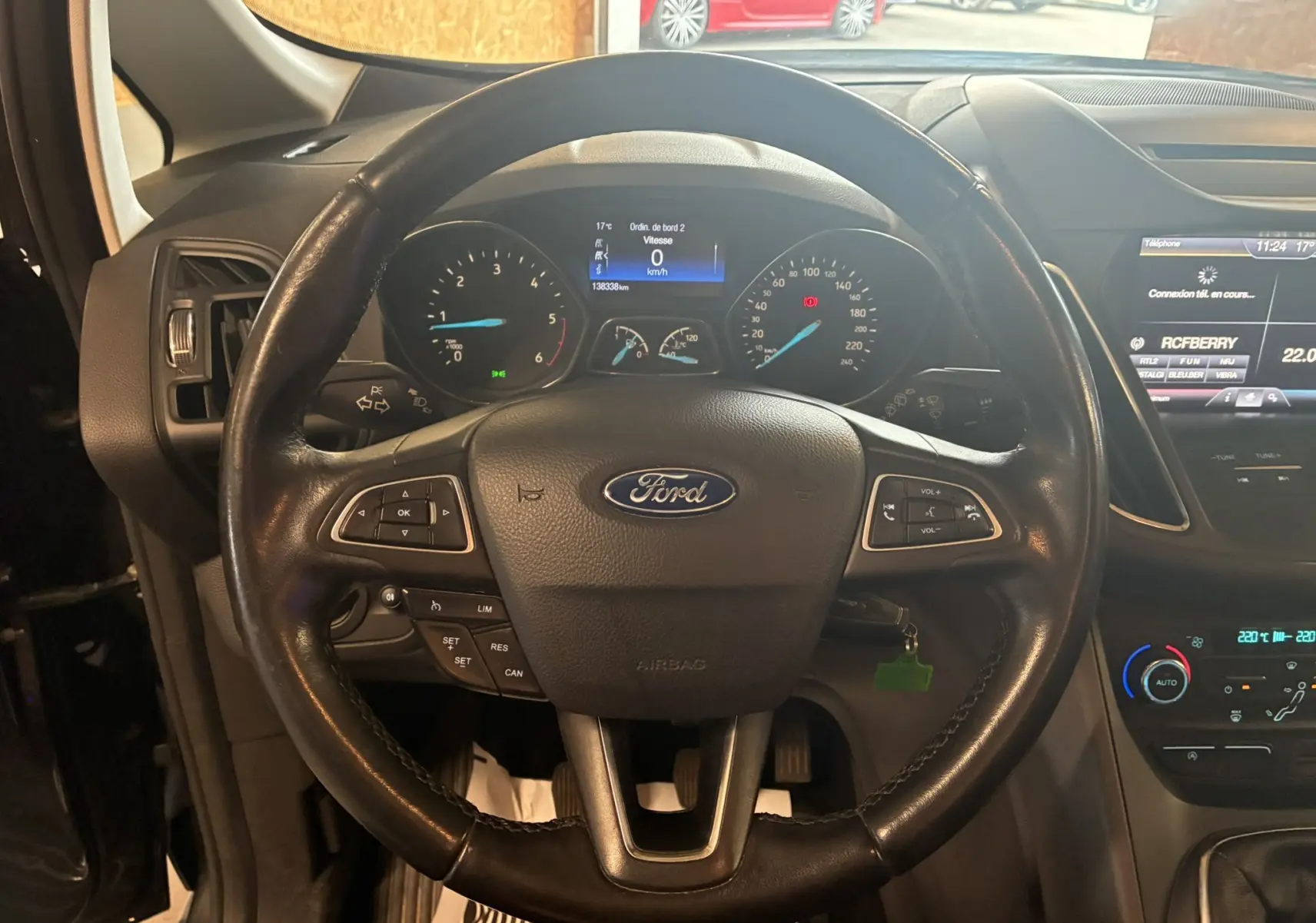 Vue centrée sur le volant en cuir noir du Ford C-MAX gris 2015, avec tableau de bord et écran tactile visibles.