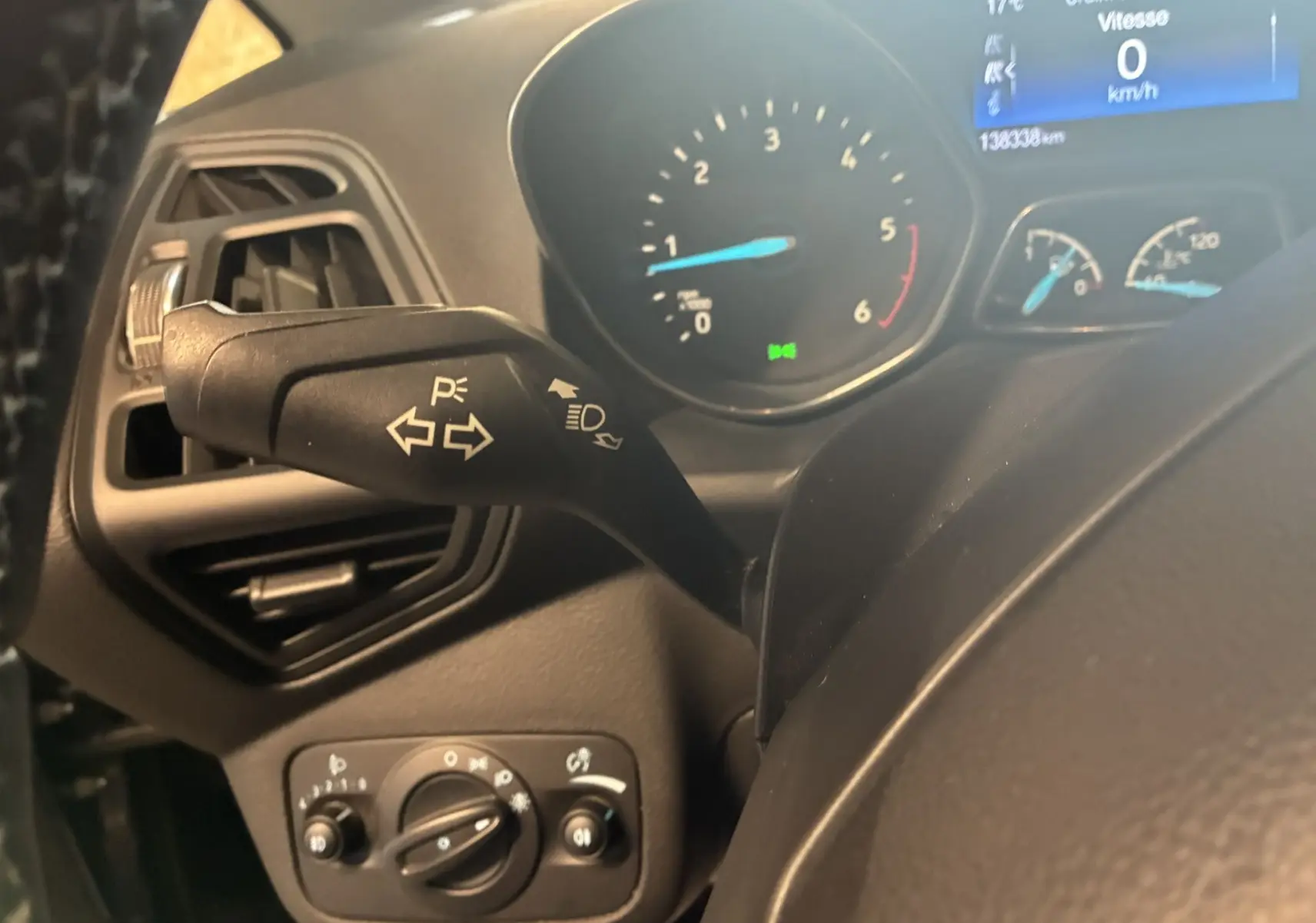 Gros plan sur la commande des clignotants et tableau de bord digital d'une Ford C-MAX gris, intérieur tissu gris-noir.