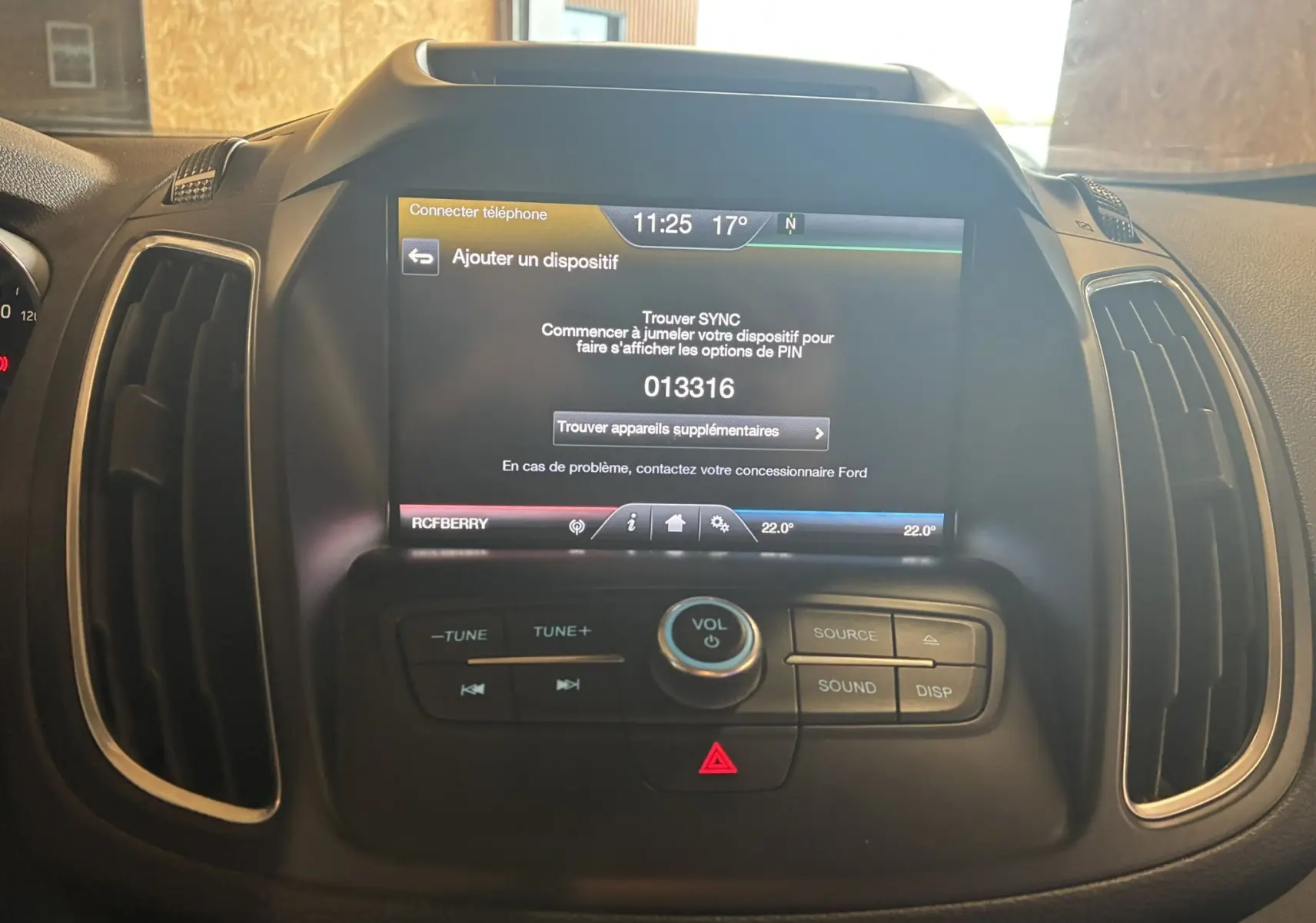 Vue rapprochée de l'écran central tactile et des commandes audio du tableau de bord d'un Ford C-MAX gris 2015.