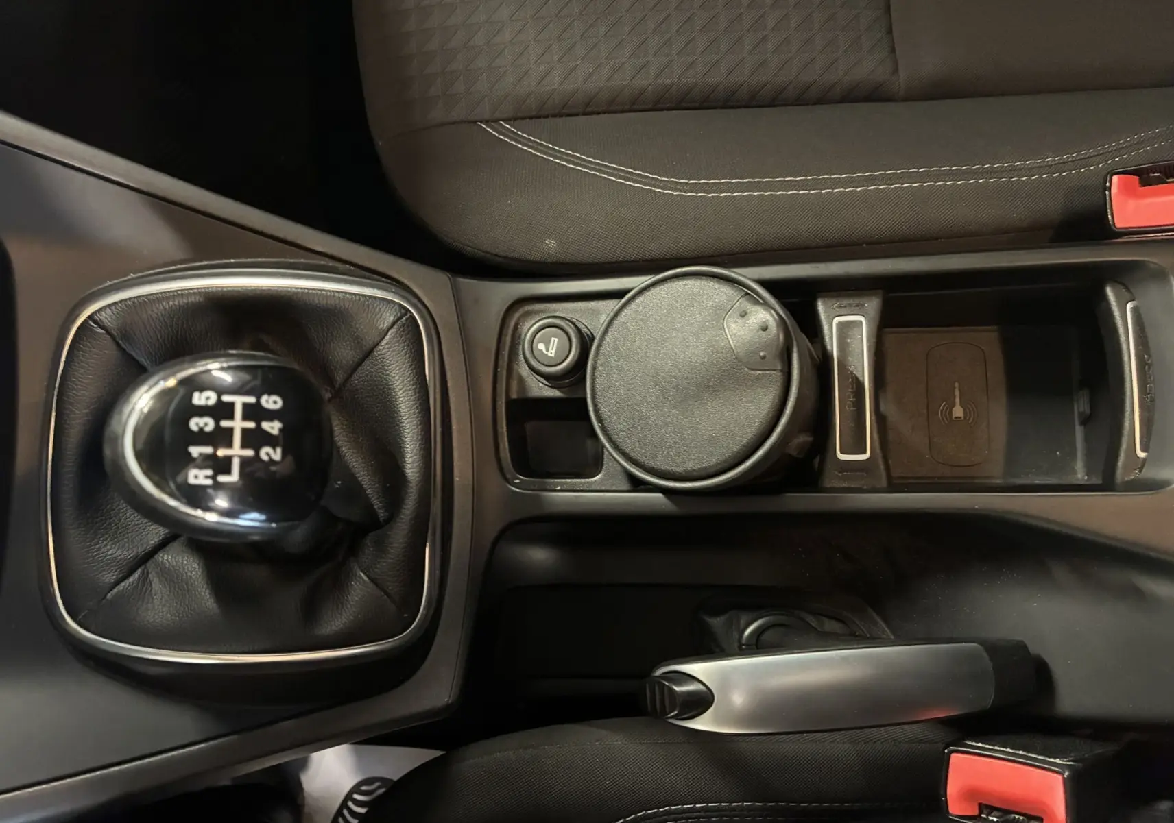 Vue rapprochée de la console centrale grise du Ford C-MAX 2015, avec levier de vitesse manuel et accoudoir noir.