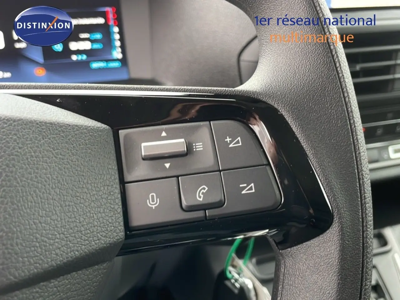 Gros plan sur les commandes au volant noir du Citroën Jumpy gris Artense, avec écran digital en arrière-plan.