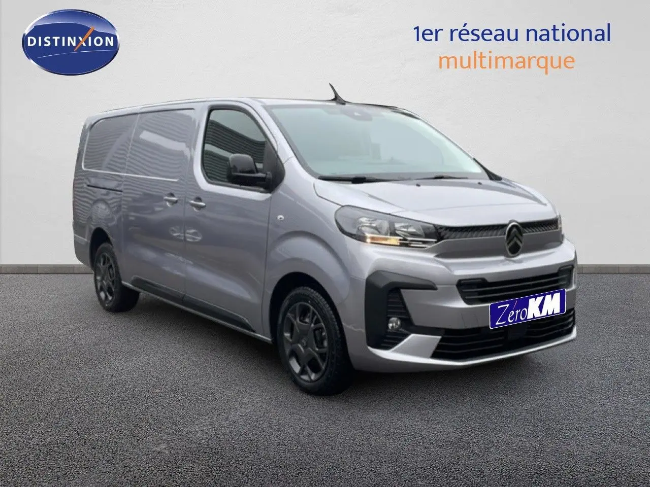 Vue 3/4 avant d'un Citroën Jumpy gris Artense métal avec calandre noire et jantes foncées sur sol gris.