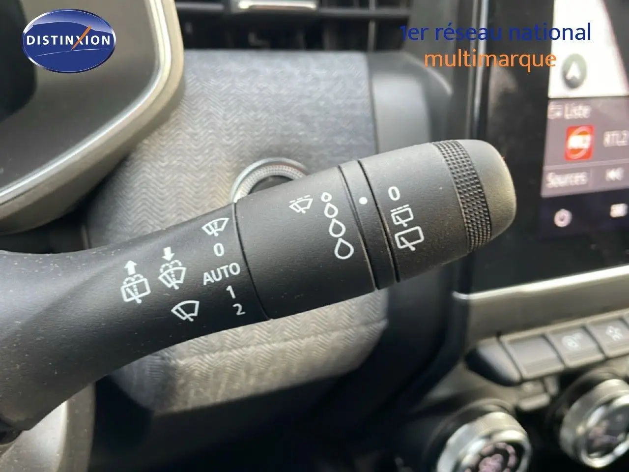 Gros plan sur la commande d’essuie-glace du tableau de bord d’une Renault Clio rouge Désir Métal 2025.