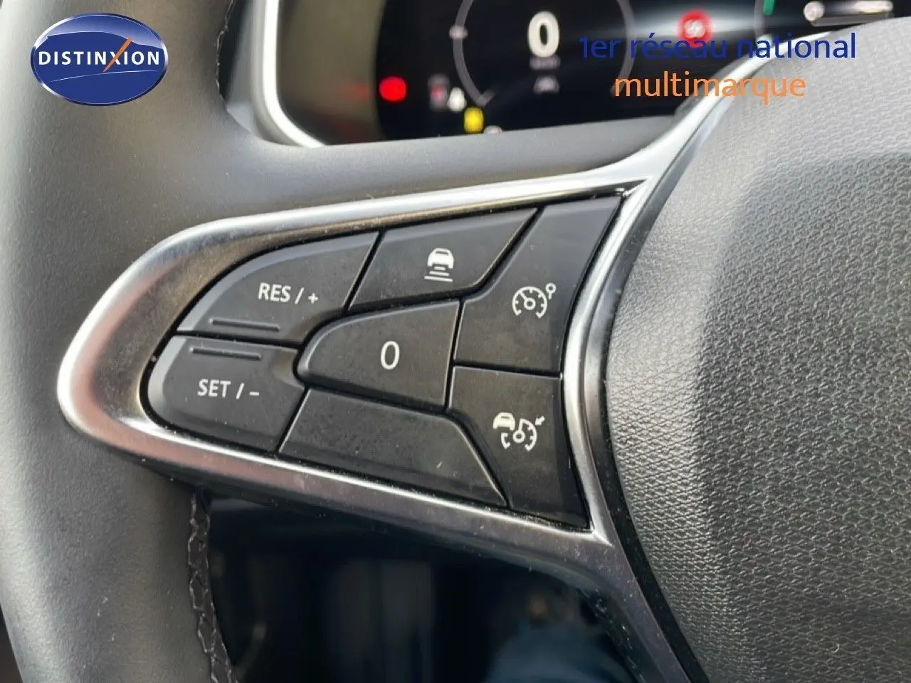 Gros plan sur les commandes au volant noir de la Renault Clio V 1.0 ECO-G 100CH TECHNO, soulignant les boutons de régulateur de vitesse.