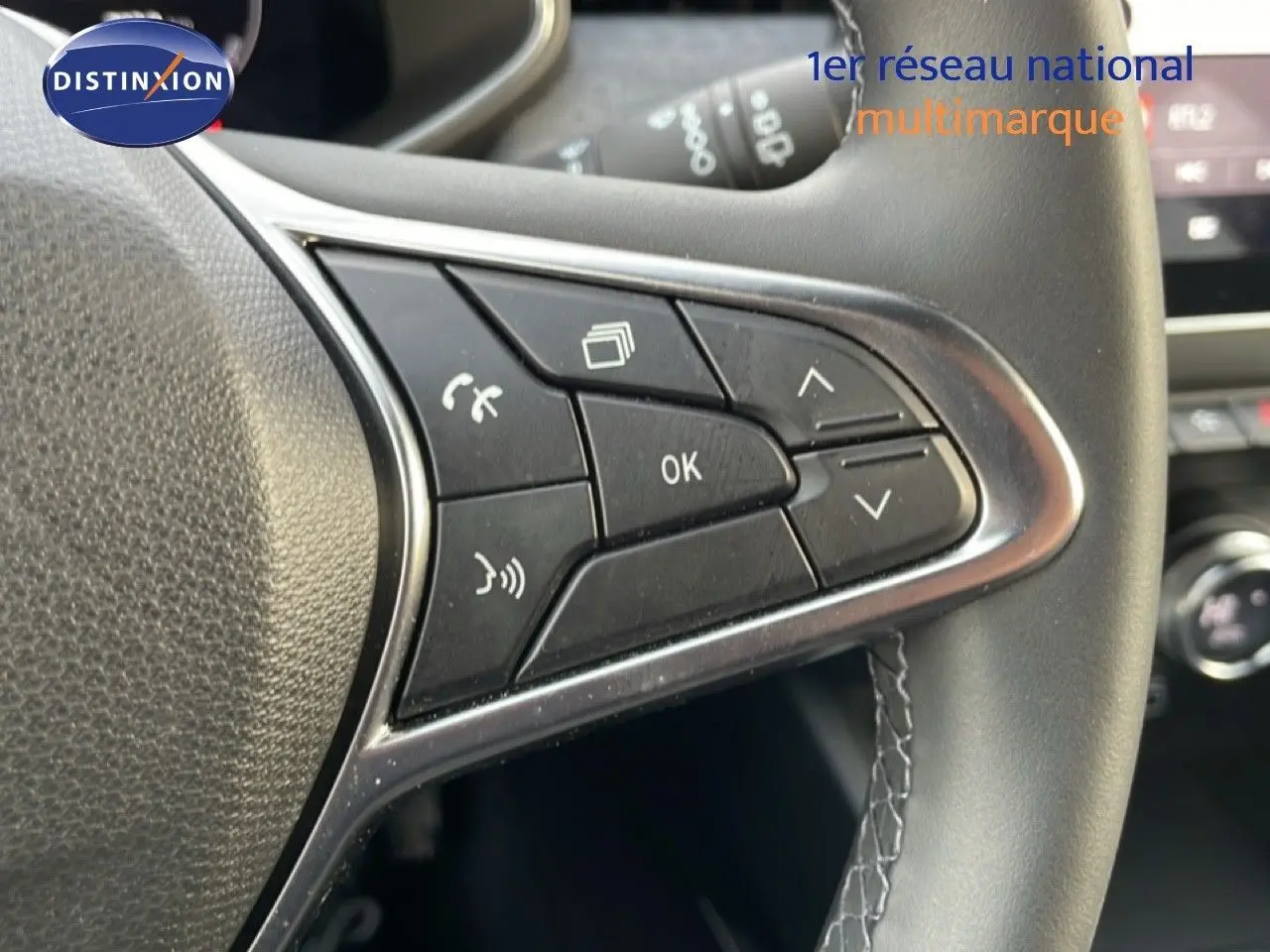 Gros plan sur les commandes multifonctions à droite du volant d’une Renault Clio 2025, cuir noir et finition chromée.