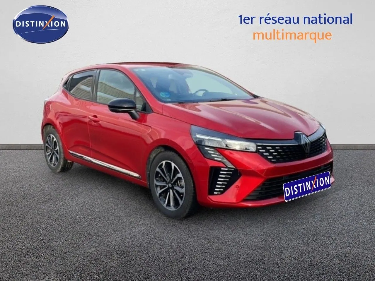 Renault Clio 2025 rouge désir métal en 3/4 avant droit, avec calandre noire et jantes alliage bicolores.