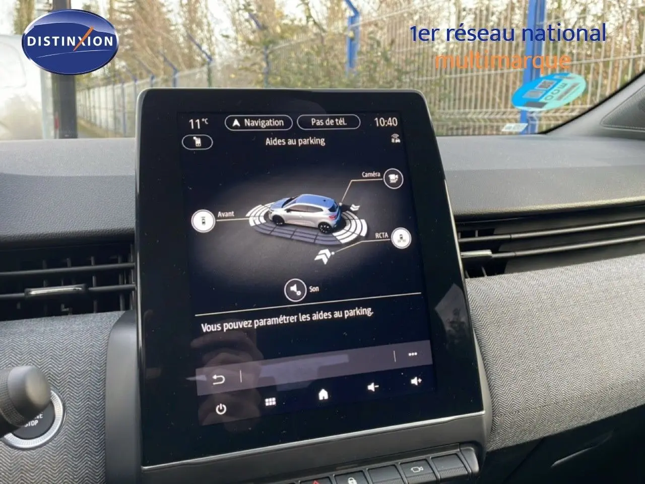 Écran tactile central de la Renault Clio 2025 affichant l'aide au parking dans un intérieur gris et noir.