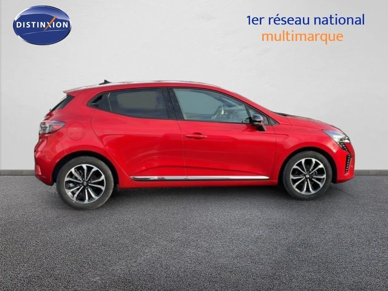 Profil droit de la Renault Clio 2025 rouge désir métal, soulignant ses jantes alliage et lignes dynamiques.