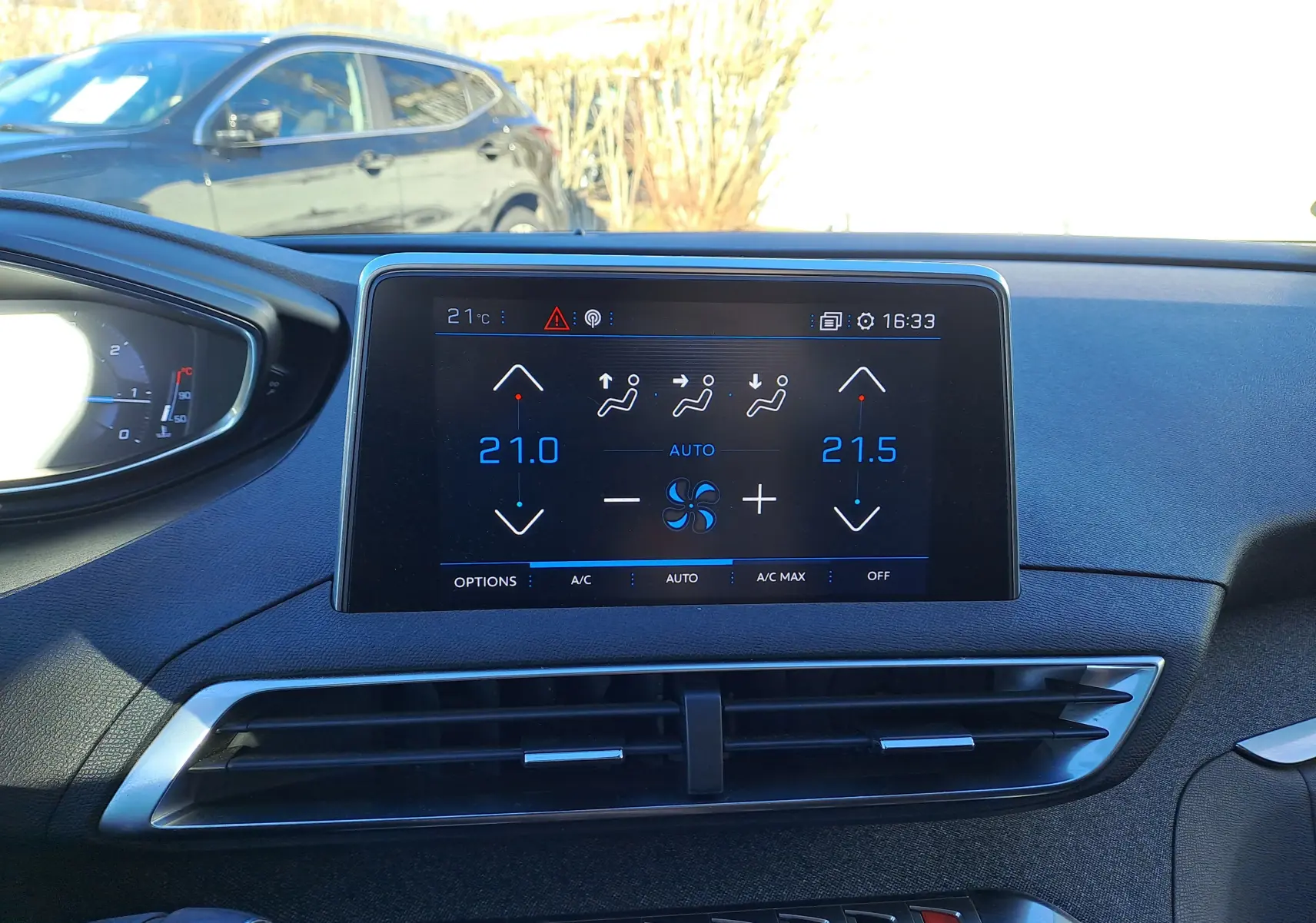 Vue intérieure du tableau de bord du Peugeot 5008 gris, écran tactile affichant la climatisation automatique.