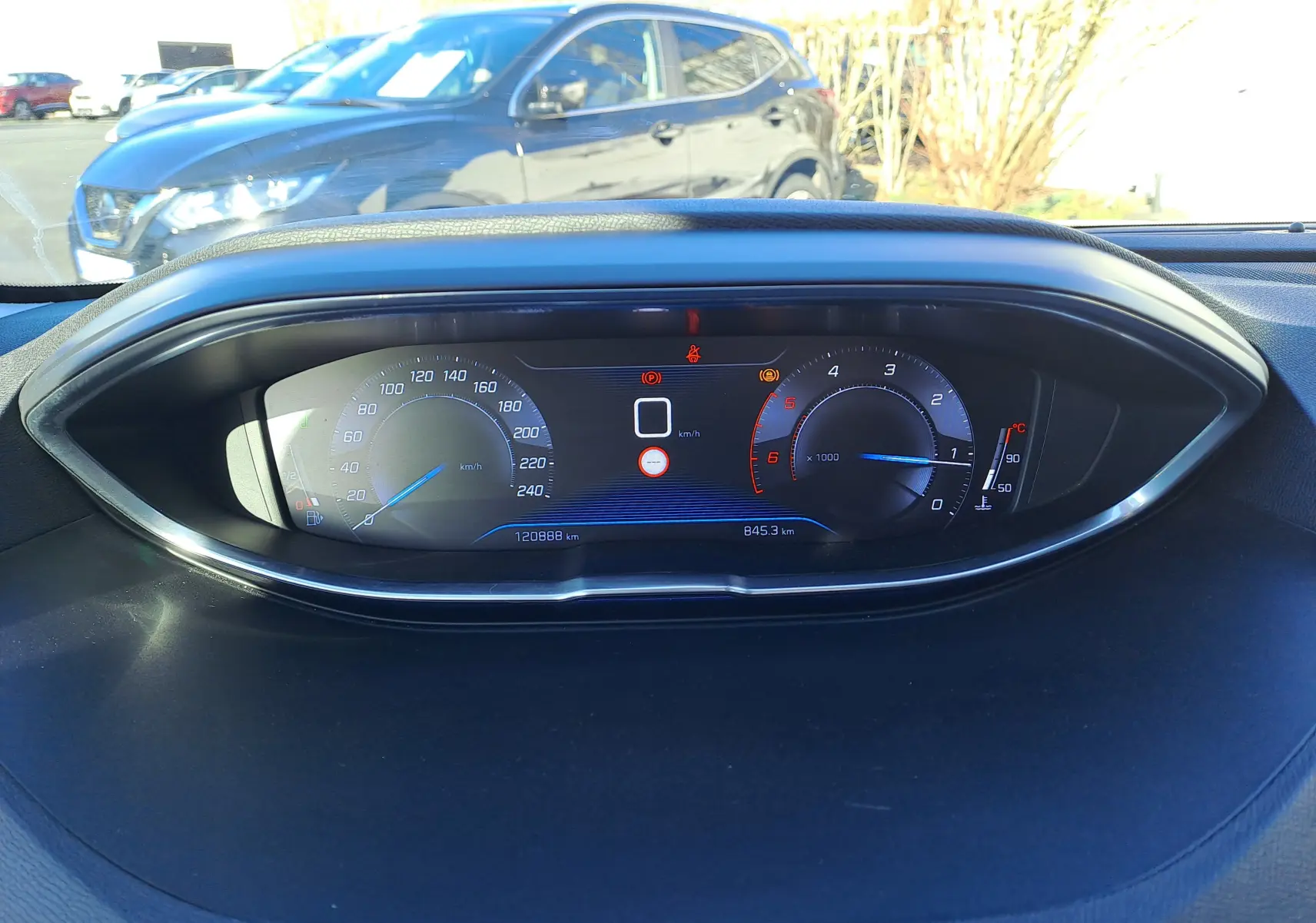 Vue intérieure du tableau de bord numérique du Peugeot 5008 gris, affichant la vitesse à 0 km/h et le compte-tours.