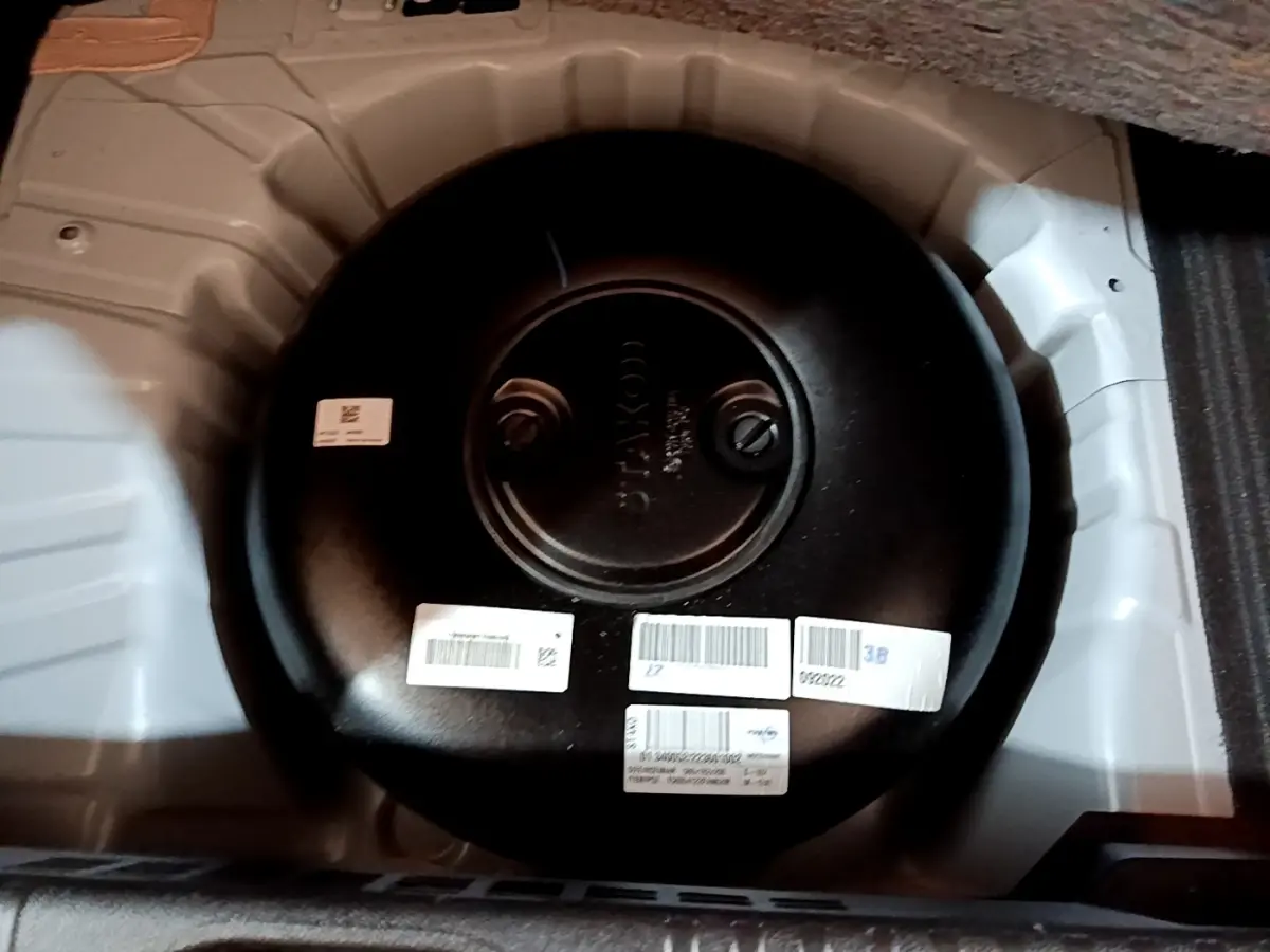 Vue rapprochée du réservoir GPL noir dans le coffre blanc d’une Renault Clio Business TCe 100 GPL 2023.