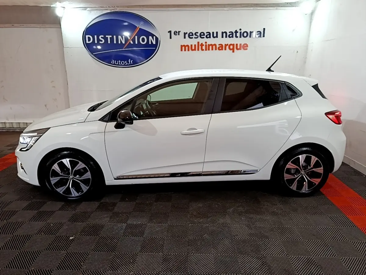 Profil droit d'une Renault Clio Business TCe 100 GPL blanche 2023 avec jantes alliage et feux LED distinctifs.