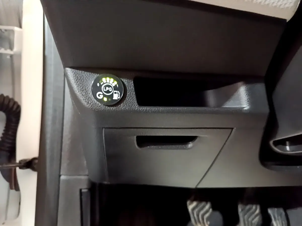 Gros plan sur le tableau de bord noir de la Renault Clio blanc, avec indicateur GPL allumé côté conducteur.