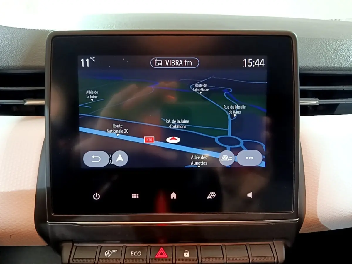 Écran tactile central affichant la navigation GPS dans l’habitacle clair d’une Renault Clio Business blanche.
